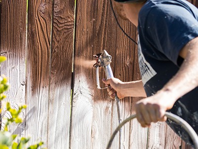 spraying a fence with an airless sprayer